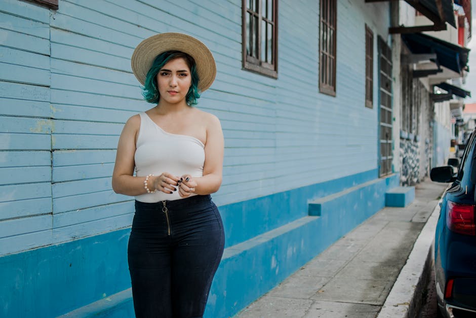 Fashionable woman with blue hair posing outdoors in a Panama street.